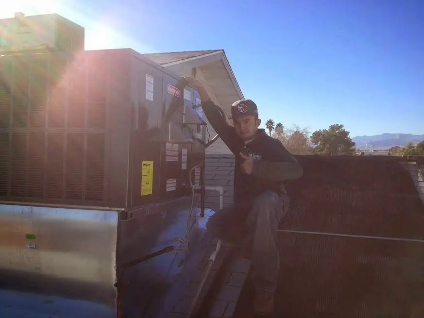 HVAC technician performing AC Tune-Up on a rooftop unit in Ware